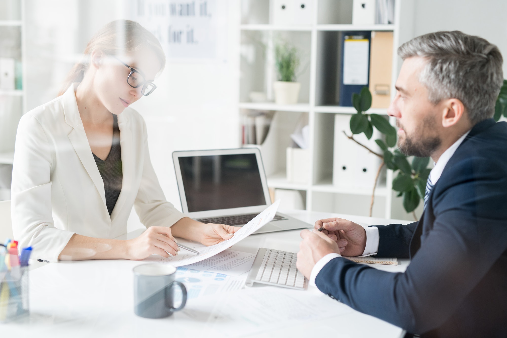 Financial adviser analyzing papers with businessman